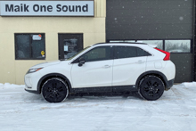 White 2019 Mitsubishi Eclipse Cross during snowfall with dark window tint